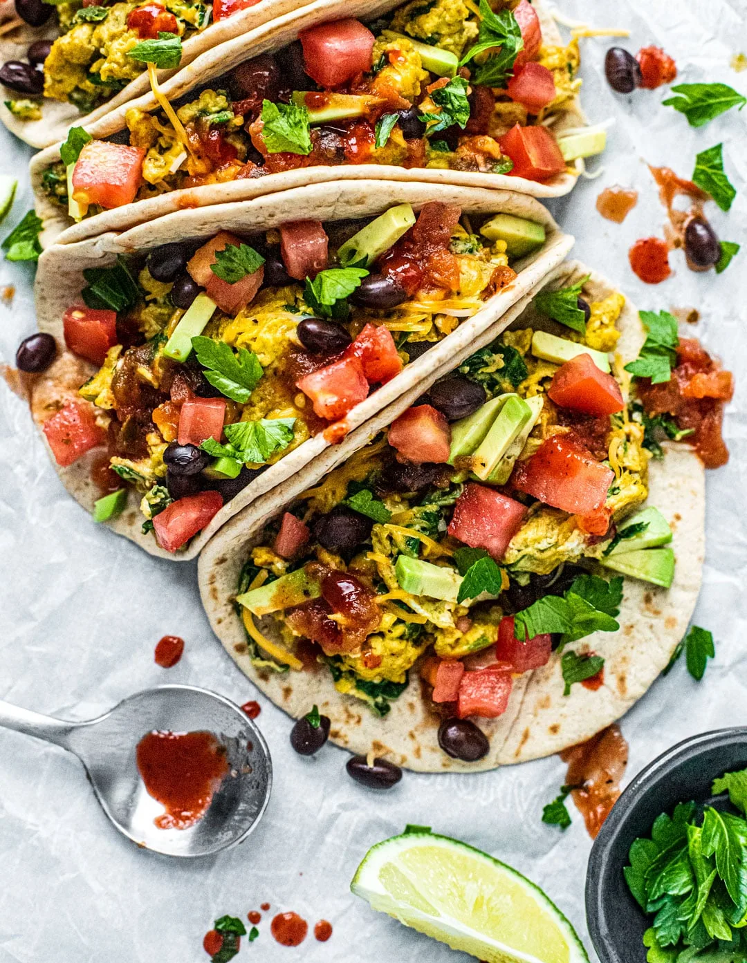 Black bean breakfast tacos topped with scrambled eggs, avocado, and fresh salsa