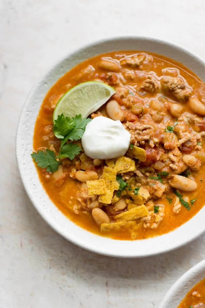 A hearty bowl of white bean and turkey chili topped with fresh herbs