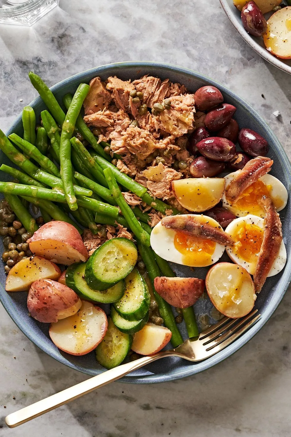 A colorful Niçoise salad with tuna, eggs, green beans, and olives