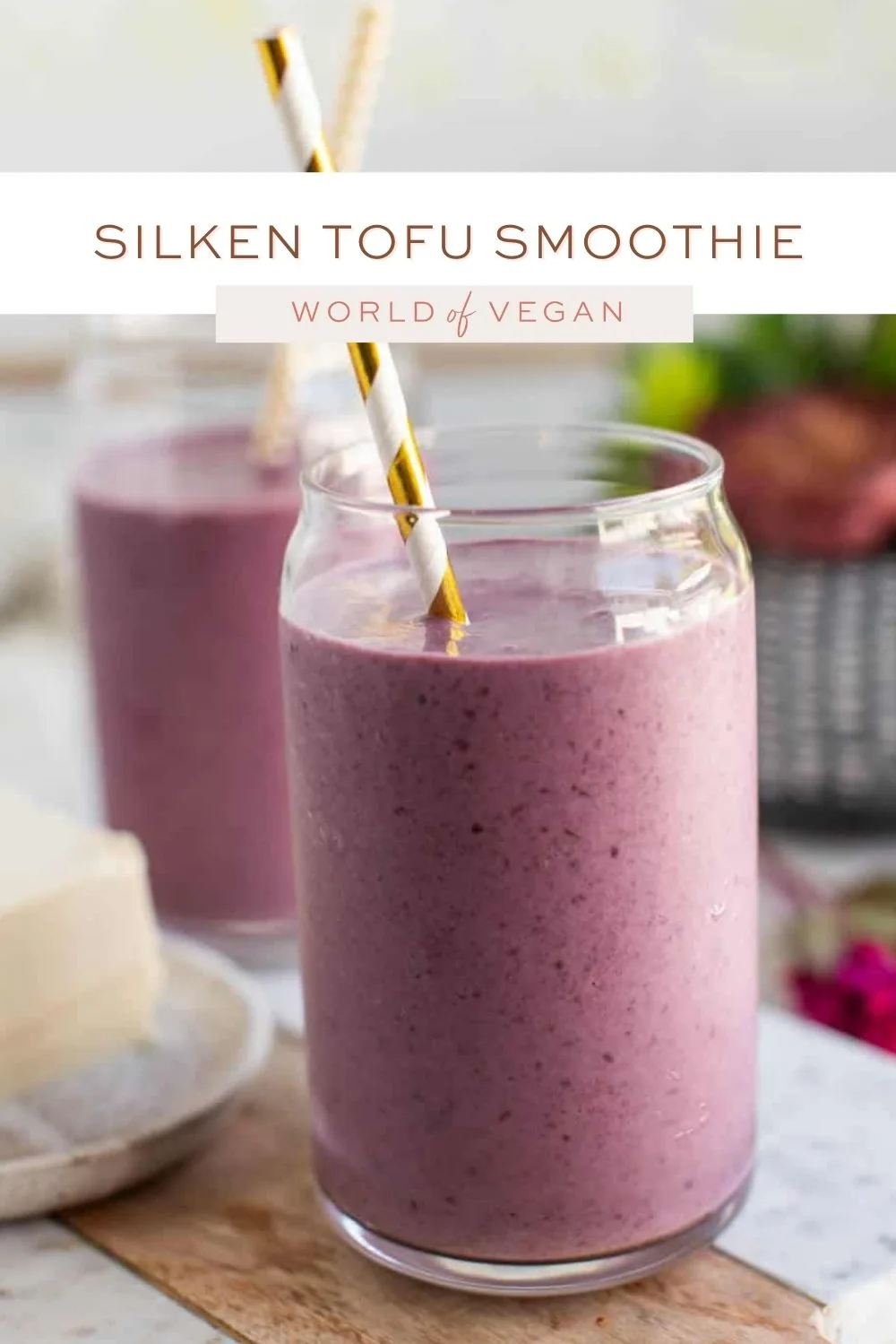 A creamy pink smoothie in a glass topped with fresh berries and seeds
