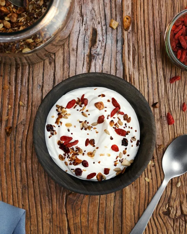 A bowl of creamy skyr topped with crunchy granola and walnuts