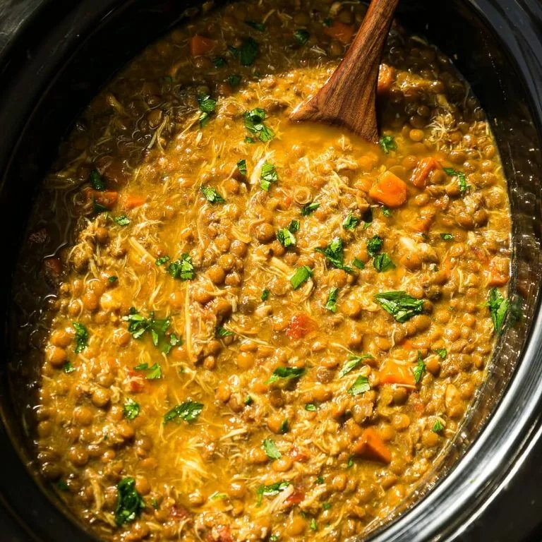 Hearty chicken and lentil stew served in a rustic bowl with herbs