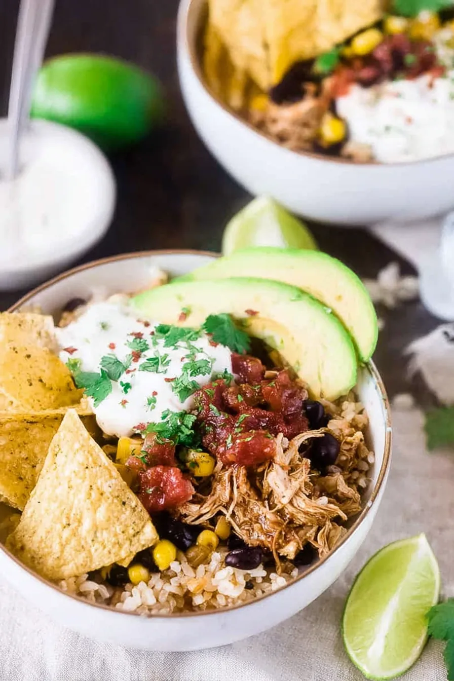 Slow cooker chicken taco bowl with brown rice, black beans, and fresh toppings