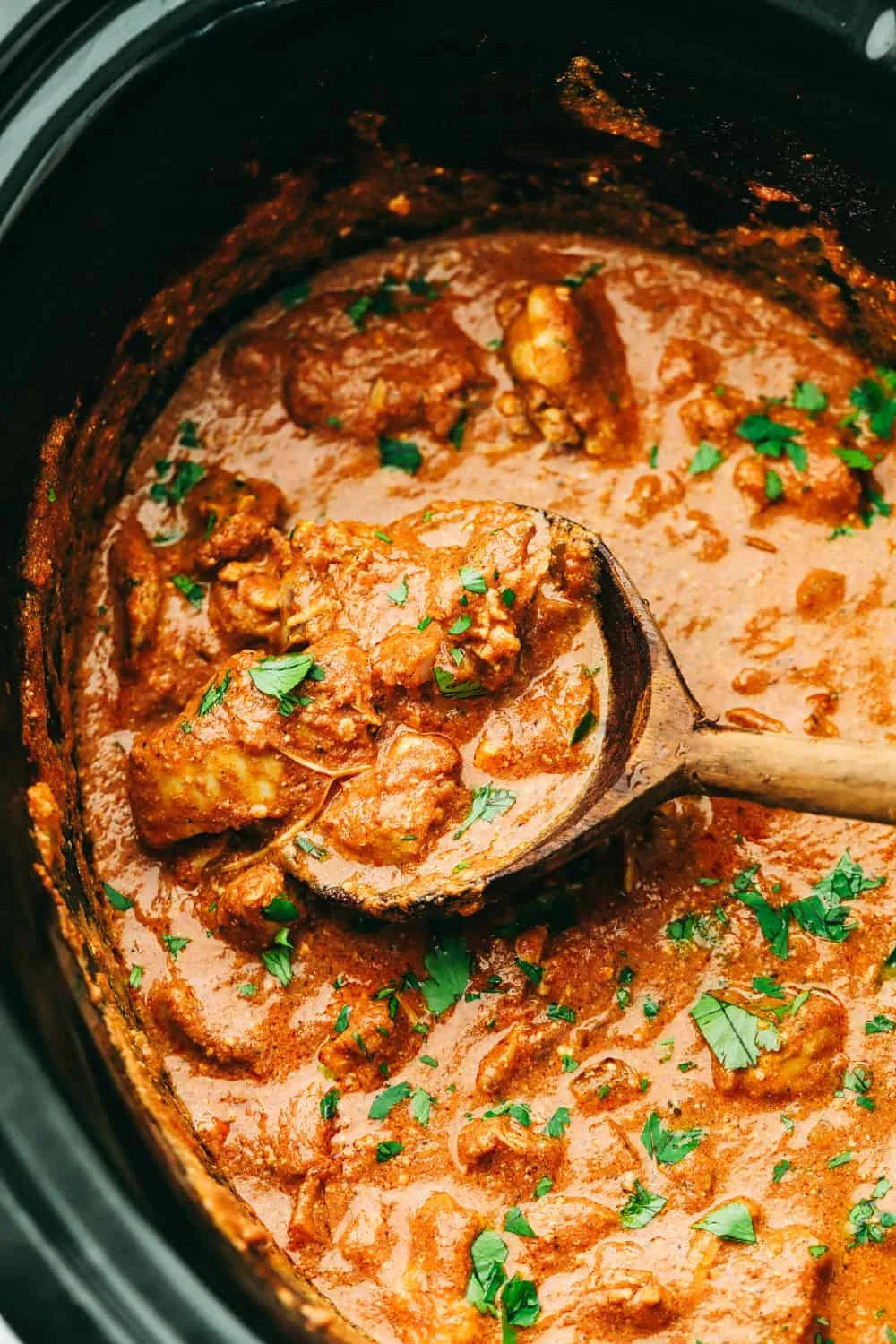 Creamy chicken tikka masala in a bowl garnished with fresh cilantro leaves