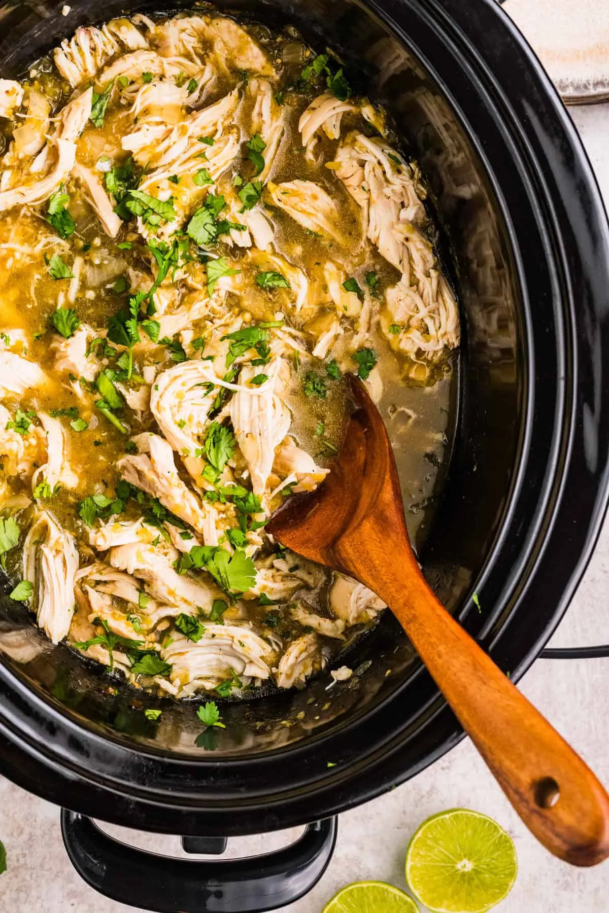 Tender shredded chicken in green salsa verde served in a white bowl